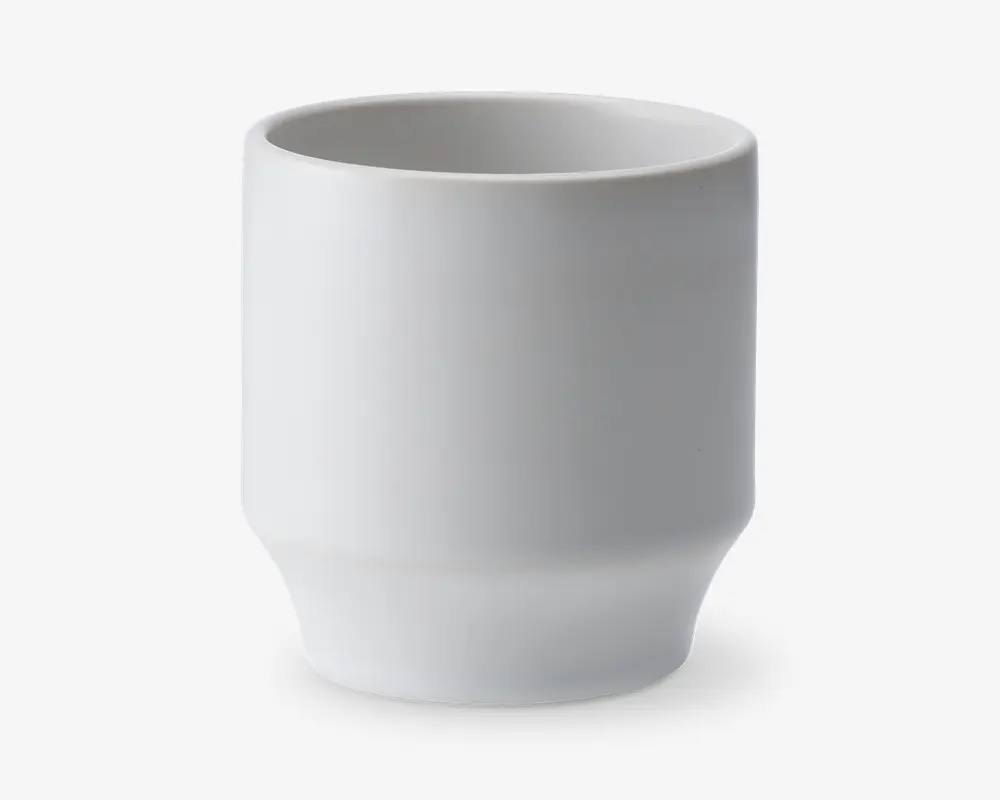 En enkel, hvid keramikkop med en glat, mat overflade. Koppen har en cylindrisk form med lige sider og en let smallere bund, hvilket giver et moderne og minimalistisk udtryk. Der er ingen hank, mønstre eller dekorationer.