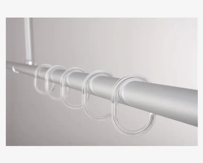 Nærbillede af flere gennemsigtige plastikringe, der hænger på en glat, metallisk stang. Ringene er jævnt fordelt og har et enkelt, afrundet design, som gør det nemt at glide dem langs stangen. Baggrunden er ensfarvet og neutral, hvilket fremhæver ringenes klare og minimalistiske stil.