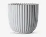 En blank, hvid keramisk beholder med lodrette riller og bølget kant. Designet er moderne og minimalistisk med jævnt fordelte riller, der løber fra bunden til toppen og giver et stilfuldt og elegant udtryk.