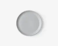En rund, ensfarvet hvid tallerken med en glat, blank overflade og en let hævet kant. Designet er minimalistisk og moderne, velegnet til både hverdagsbrug og formelle middage.
