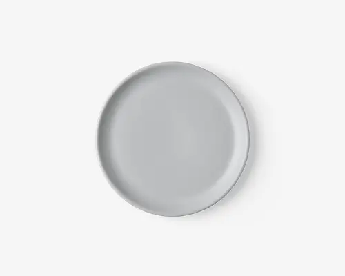 En rund, ensfarvet hvid tallerken med en glat, blank overflade og en let hævet kant. Designet er minimalistisk og moderne, velegnet til både hverdagsbrug og formelle middage.