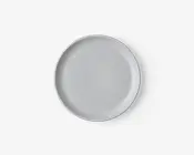 En rund, ensfarvet hvid tallerken med en glat, blank overflade og en let hævet kant. Designet er minimalistisk og moderne, velegnet til både hverdagsbrug og formelle middage.