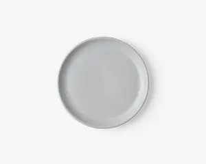 En rund, ensfarvet hvid tallerken med en glat, blank overflade og en let hævet kant. Designet er minimalistisk og moderne, velegnet til både hverdagsbrug og formelle middage.