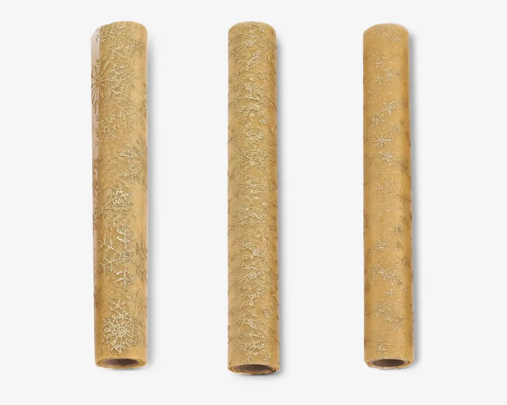 Tre cylindriske ruller brunt kraft gavepapir, hver med et diskret, gentagende mønster af hvide snefnug. Papiret har en mat overflade, og snefnugdesignene varierer i størrelse og stil, hvilket giver et festligt og elegant udtryk, der egner sig til gaveindpakning i juletiden.