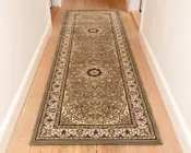 Lang, rektangulær løber med et indviklet blomster- og medaljonmønster i dæmpede grønne, beige og bordeaux nuancer. Tæppet har en detaljeret kant med snoede motiver og små blomsterdetaljer, og midterområdet viser to cirkulære medaljoner. Luvet ser lav ud, og kanterne er pænt afsluttet.