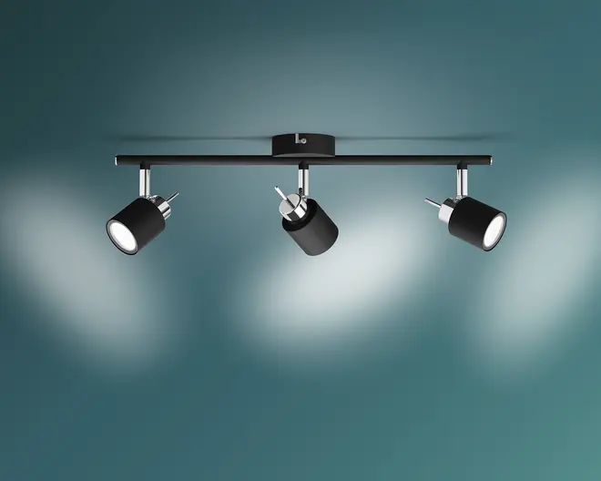 Loftmonteret lampearmatur med tre justerbare cylindriske spotlys i mat sort finish og kromdetaljer. Hvert spotlys kan vinkles individuelt for at rette lyset efter behov. Armaturet er monteret på en slank, vandret stang med en central monteringsbase, hvilket giver en moderne og alsidig belysningsløsning til forskellige rum.