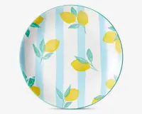Rund tallerken med et mønster af lysegule citroner med grønne blade, placeret på en baggrund med skiftevis lyseblå og hvide lodrette striber. Tallerkenens kant er markeret med en tynd turkis linje.