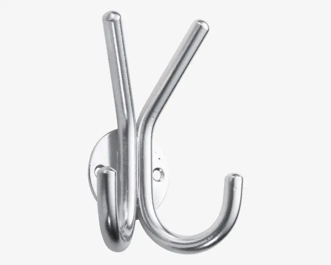 En vægkrog i metal med børstet sølvfinish, der har tre kroge: to peger opad i en vinkel, og én er buet nedad. Basen er ovalformet med to synlige skruehuller til montering. Designet er robust og velegnet til ophæng af jakker, hatte eller tasker.