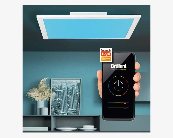 Rektangulær loftlampe med en moderne, slank hvid ramme og et blåt oplyst panel. Lampen er vist i et nutidigt rum. En hånd holder en smartphone med en smart belysnings-app, der viser, at lampen kan fjernstyres med muligheder for tænd/sluk, farve- og lysstyrkeregulering. Appen er mærket 'Brilliant' og har 'Powered by Tuya' smart home-integration.