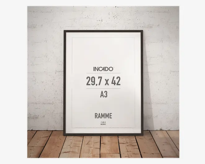Rektangulær ramme med en tynd, sort kant, der passer til A3-format (29,7 x 42 cm). Rammen har et moderne, minimalistisk design og står oprejst mod en hvid, tekstureret væg på et trægulv. Fronten er klar glas eller akryl, og rammen egner sig til plakater, fotos eller kunstværker.
