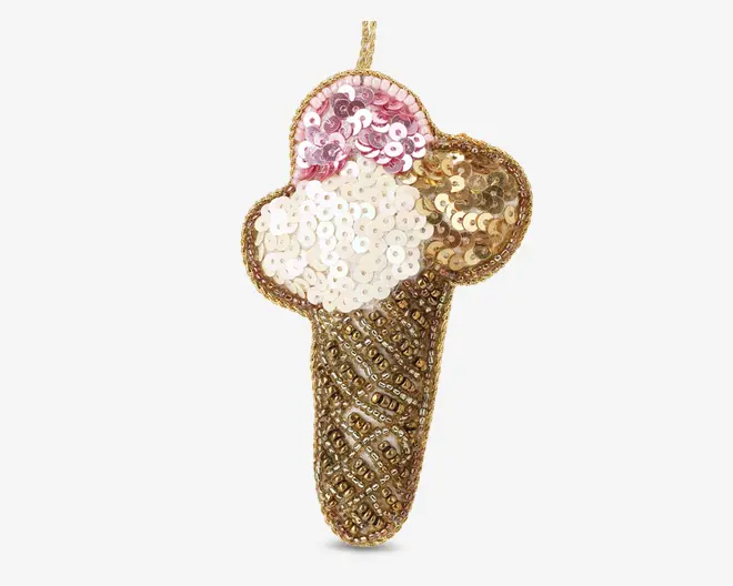 Dekorativt patch formet som en isvaffel, udsmykket med pailletter og perler. Vaflen er dækket af gyldne perler arrangeret i et krydsmønster, mens de tre kugler er dekoreret med pailletter i pink, hvid og guld, hvilket giver et skinnende og tekstureret udseende. Patchen har en løkke øverst for nem fastgørelse.