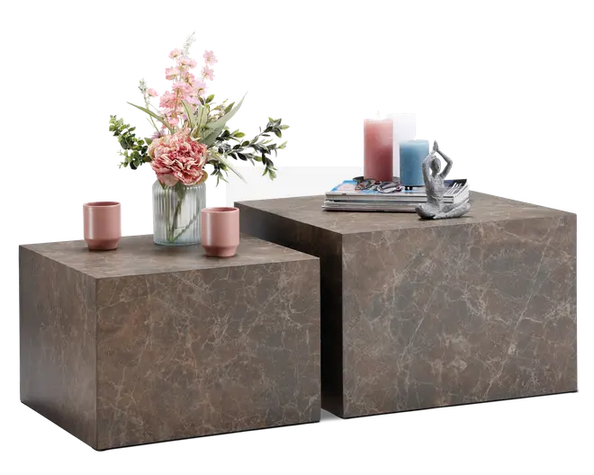 Sæt med to firkantede sideborde i forskellige højder med marmorlignende overflade i brun med diskrete hvide årer. Bordene har et moderne, minimalistisk kube-design. Det ene bord er pyntet med en glasvase med lyserøde og hvide blomster samt to lyserøde kopper, mens det andet har en stak bøger, dekorative lys i lyserød og blå samt en lille abstrakt skulptur.