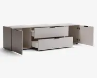 Rektangulær opbevaringsenhed med en glat, lys overflade. Den har to brede skuffer i midten, begge delvist åbne, samt to sidekabinetter med hængslede låger, som også er åbne. Håndtagene er minimalistiske og mørke, hvilket giver et moderne udtryk. Indersiden af kabinetterne og skufferne er rummelig og egnet til organisering af forskellige genstande.