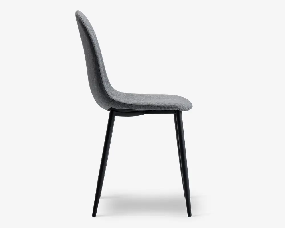 Sidebillede af en moderne stol med let buet, polstret ryg og sæde i blødt gråt stof. Stolen har slanke, sorte metalben, der er let udadgående, hvilket giver et minimalistisk og moderne udtryk. Sæde og ryg er sømløst forbundet og giver ergonomisk støtte.
