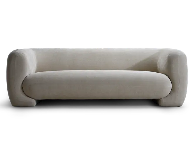 Lavt polstret sidemøbel i lysebeige stof med afrundede armlæn, dybt polstret sæde og et rent, minimalistisk udtryk.