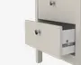 Nærbillede af en lys beige skuffeenhed med to skuffer, hvoraf den ene er delvist åben. Skufferne har runde, metalgreb for nem håndtering. Indersiden af den åbne skuffe viser en glat, hvid finish og solide metalskinner, der sikrer let åbning og lukning. Designet er enkelt og moderne med rene linjer og en mat overflade.