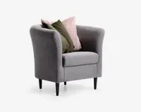 En moderne lænestol betrukket med lysegråt stof, med rund ryg og armlæn for ekstra komfort. Stolen står på fire slanke, sorte, koniske ben. Den er pyntet med to dekorative puder: én i en afdæmpet lyserød nuance og én i olivengrøn, som begge tilfører farve og blødhed til det samlede udtryk.