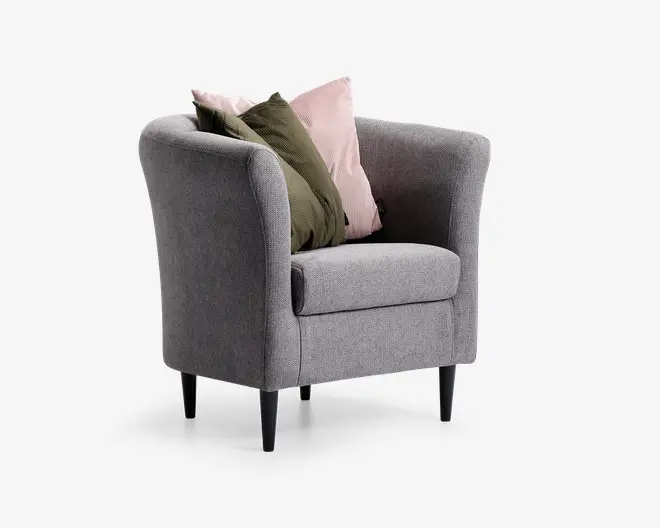 En moderne lænestol betrukket med lysegråt stof, med rund ryg og armlæn for ekstra komfort. Stolen står på fire slanke, sorte, koniske ben. Den er pyntet med to dekorative puder: én i en afdæmpet lyserød nuance og én i olivengrøn, som begge tilfører farve og blødhed til det samlede udtryk.