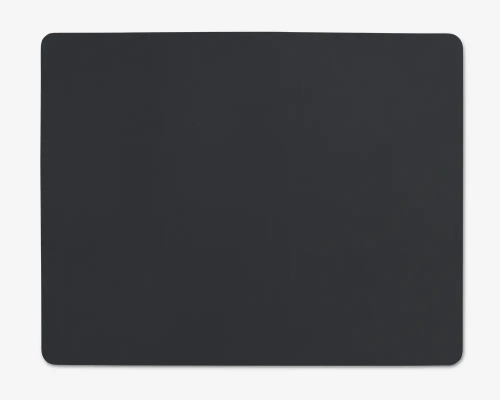 En stor, rektangulær måtte med afrundede hjørner og en glat, ensfarvet sort overflade. Kanterne er pænt afsluttede, og måtten er flad og ensartet i teksturen, hvilket gør den velegnet til at give et stabilt og behageligt underlag.
