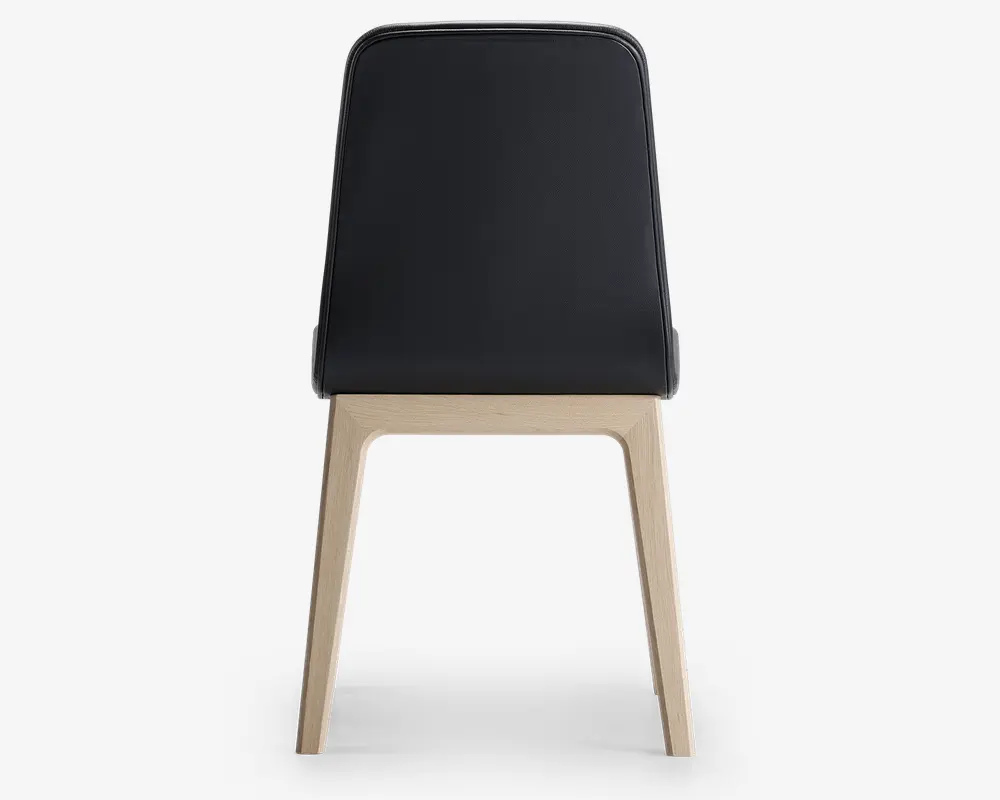 Stol med et slankt, sort polstret ryglæn og sæde, der har et minimalistisk design. Benene og stellet er lavet af lyst træ med en naturlig finish og er vinklet udad for stabilitet. Udseendet er moderne og enkelt, velegnet til nutidige indretninger.