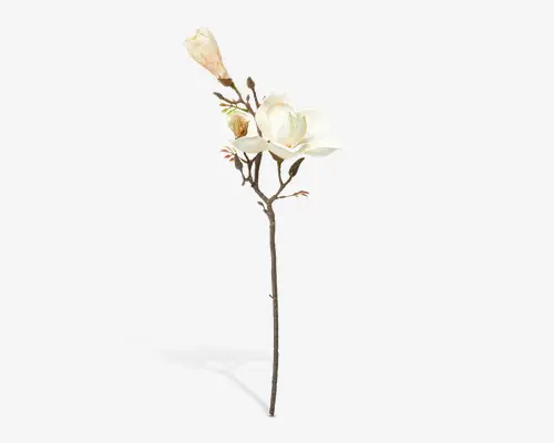Kunstig blomsterstilk med en stor hvid magnoliablomst med naturtro kronblade, en lukket knop og en lille frøkapsel. Stilken er brun med forgrenede detaljer og har grønne blade samt diskrete glimmerdetaljer for et dekorativt udtryk.