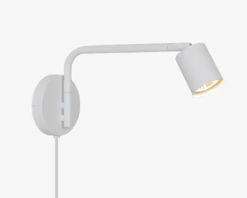 Hvid vægmonteret spotlampe med rund bagplade, buet arm og justerbart cylindrisk lampehoved vinklet nedad.