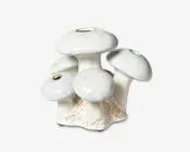 Keramisk vase formet som en klynge af fem svampe, hver med en rund hat og en lille åbning i toppen til blomster. Overfladen er blank hvid med diskrete blå og beige nuancer, og bunden har teksturerede, jordfarvede detaljer, der efterligner naturlige svampestilke.