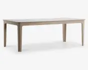 Rektangulært bord med en glat, lys bordplade og matchende ben. Bordet har et minimalistisk design med let afrundede hjørner og kanter, og benene er lige med diskrete indadgående kurver øverst. Overfladen har en mat finish, hvilket giver et moderne og rent udtryk.