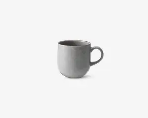 En enkel, moderne kop med en glat, mat lysegrå overflade. Koppen har en rundet form og et stort, behageligt håndtag. Indersiden er også grå og matcher ydersiden. Designet er minimalistisk uden mønstre eller dekorationer.
