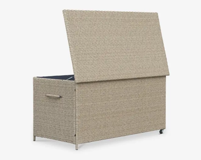Rektangulær opbevaringskasse med flettet rattan-lignende ydre i en lys beige farve. Låget er hængslet og vist åbent, hvilket afslører et rummeligt indre. Kassen har solide sidehåndtag for nem transport og små hjul i bunden for mobilitet. Designet er moderne og egnet til både udendørs og indendørs brug.