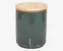 Cylindrisk beholder med en glat, blank mørkegrøn keramisk krop og et fladt, rundt låg af lyst træ. Låget passer tæt på toppen, og keramikken har diskrete farvevariationer og en let plettet overflade.