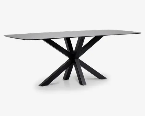 Rektangulært bord med en glat, lysegrå bordplade og en markant sort metalbase, der består af flere skråtstillede ben, som mødes i midten og danner et moderne, geometrisk stjernemønster. Bordet har rene linjer og et minimalistisk udtryk.