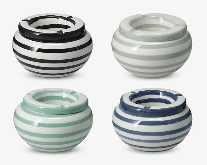 Sæt med fire runde askebægre i keramik, hver med blank overflade og vandrette striber i forskellige farver: sort, lysegrå, mintgrøn og marineblå. Hvert askebæger har en bred kant med tre riller til cigaretter og en dyb skålform. Striberne er jævnt fordelt og giver et moderne og stilfuldt udtryk.