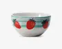 Hvid keramikskål med et legende design af store røde jordbær og grønne blade rundt om ydersiden. Skålen har også vandrette turkisblå striber nær kanten, som giver et farverigt præg. Indersiden er ensfarvet hvid, og skålen har en glat, blank overflade.