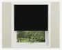Et vindue med en sort rullegardin, der er trukket halvt ned og dækker den øverste halvdel af vinduet. Gardinet har en glat, ensfarvet sort overflade og er monteret inden for en hvid vinduesramme. Den nederste halvdel af vinduet er fri, så man kan se ud til et grønt udendørs landskab med træer og græs.