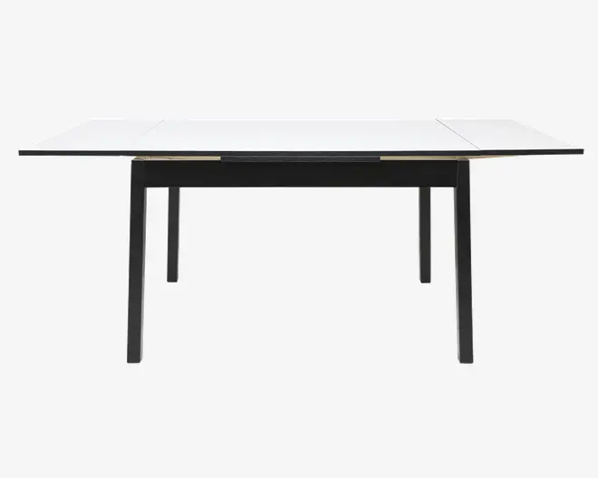 Rektangulært bord med et slankt, moderne design med hvid bordplade og sorte ben. Bordet har udtræksplader i begge ender, så det kan udvides til flere siddepladser. Benene er lige og stabile, hvilket giver god støtte. Udtrykket er minimalistisk og nutidigt.