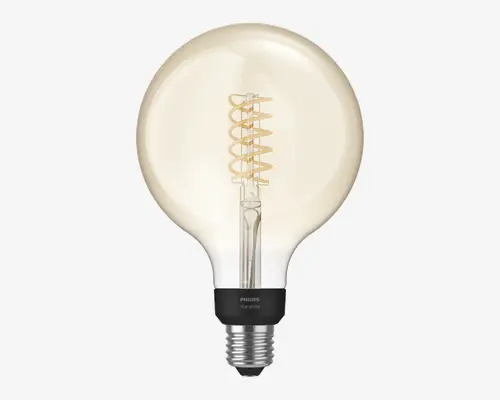 Stor, rund glaspære med klart glas og synlig spiralformet LED-filament indeni, som udsender et varmt hvidt lys. Pæren har en sølvfarvet skruesokkel og en sort krave med Philips-logo og teksten 'Hue white'. Designet er dekorativt og velegnet til lamper, hvor pæren er synlig.