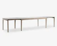 Rektangulært bord med lys træfinish, designet med en lang og udvidet form, der egner sig til mange siddepladser. Bordet har rene, lige linjer og seks slanke ben, hvilket giver det et moderne og minimalistisk udtryk.