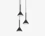 Tre pendellamper med mat sorte, kegleformede skærme, hver ophængt i en sort ledning i forskellige højder. Lampeskærmenes inderside er hvid, hvilket giver en ren kontrast og forbedrer lysrefleksionen. Designet er moderne og minimalistisk, velegnet til nutidige indretninger.