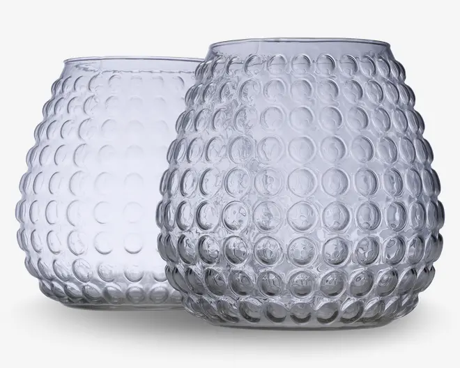 To runde, klare glasbeholdere med bred åbning og en overflade dekoreret med et hævet boblemønster over det hele. Glasset er tykt, og mønsteret giver et dekorativt og taktilt udtryk. Begge beholdere har en let flad bund for stabilitet.