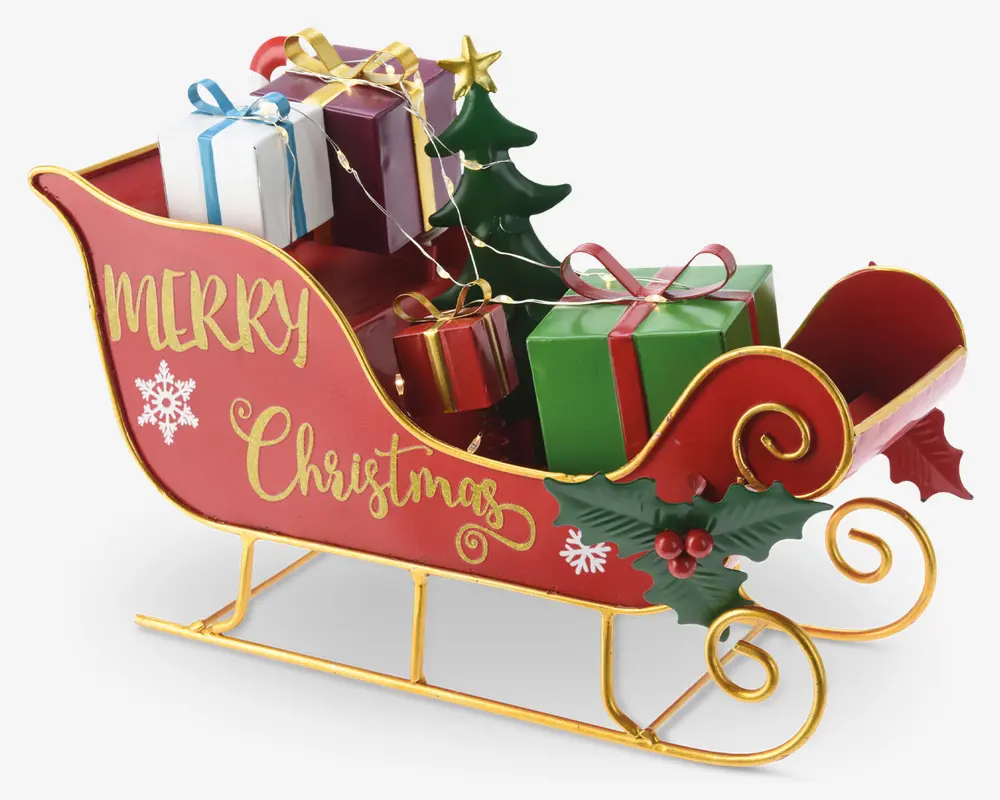 Festlig rød slæde med guldfarvede kanter og dekorative kristtorn-detaljer, med teksten 'Merry Christmas' skrevet med gul skrift på siden. Slæden er fyldt med farverige indpakkede gaver, et lille grønt juletræ og lyskæde, hvilket skaber en glad juleudstilling.