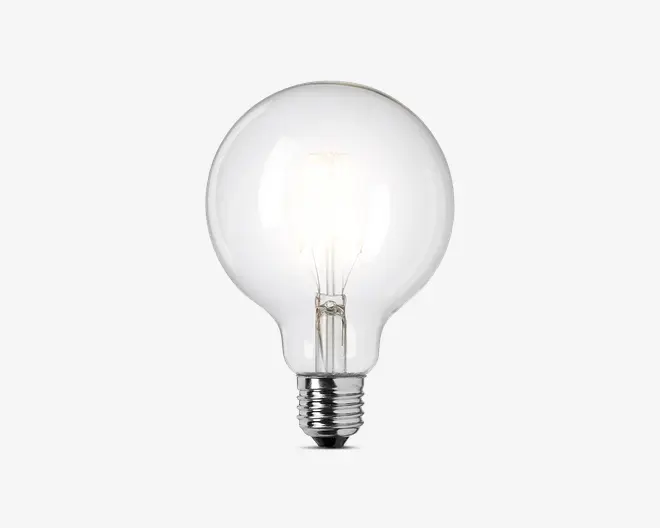 Klar glaspære med rund, globusformet design og synlig glødetråd indeni. Soklen er af metal med standard skruefatning, der passer til de fleste lamper. Det gennemsigtige glas giver maksimal lysudbytte og et klassisk, dekorativt udseende.