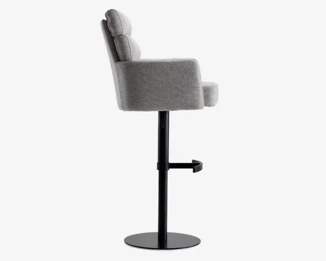 Sideview af en moderne stol med gråt polstret sæde, ryglæn og armlæn. Stolen har en polstret ryg og sæde for komfort, en sort metalfod med rund base samt en integreret fodstøtte monteret på den centrale støtte.