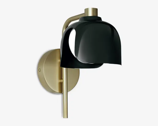 Væghængt lampe med en rund base i børstet messing og en elegant, buet messingarm. Lampen har en blank, sort, kuppelformet skærm, der leder lyset nedad og giver et moderne og stilfuldt udtryk. Kombinationen af messing og sort finish skaber et sofistikeret, nutidigt design.