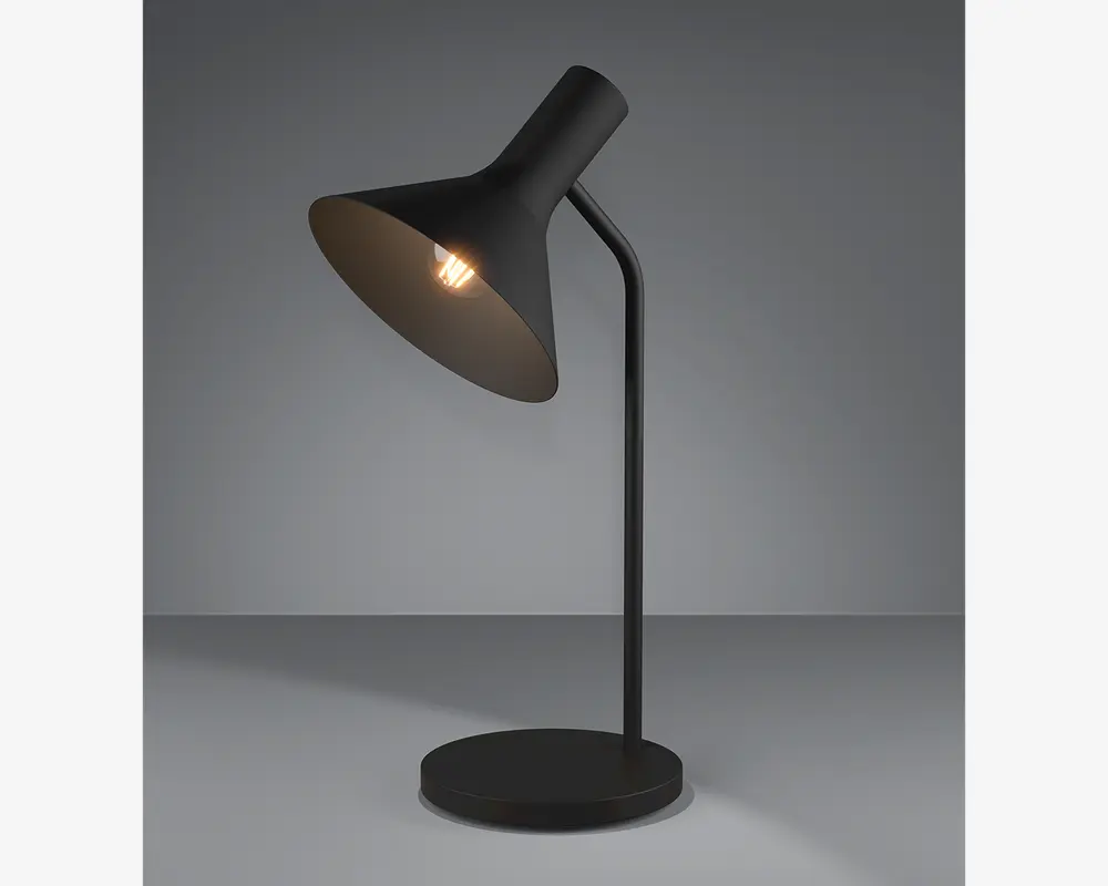 En moderne bordlampe med mat sort finish, der har en konisk skærm vinklet nedad. Lampen har en slank, buet stang, der er fastgjort til en rund, flad fod. Pæren er synlig inde i skærmen og udsender et varmt lys. Designet er minimalistisk og passer til moderne indretning.
