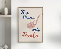 En indrammet plakat med et minimalistisk design, der viser teksten 'No Drama only Pasta' i legende blå og røde håndskrevne skrifttyper. Plakaten har også en enkel stregtegning af en gaffel med snoet spaghetti, som matcher den røde farve i ordet 'Pasta'. Baggrunden er råhvid, og rammen er i lyst træ.