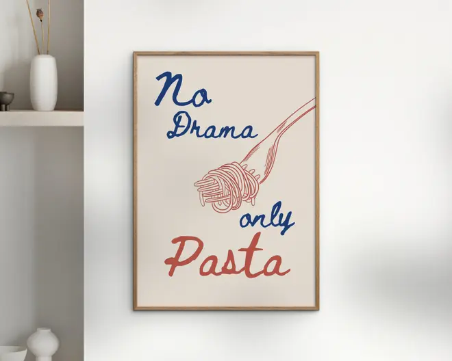 En indrammet plakat med et minimalistisk design, der viser teksten 'No Drama only Pasta' i legende blå og røde håndskrevne skrifttyper. Plakaten har også en enkel stregtegning af en gaffel med snoet spaghetti, som matcher den røde farve i ordet 'Pasta'. Baggrunden er råhvid, og rammen er i lyst træ.