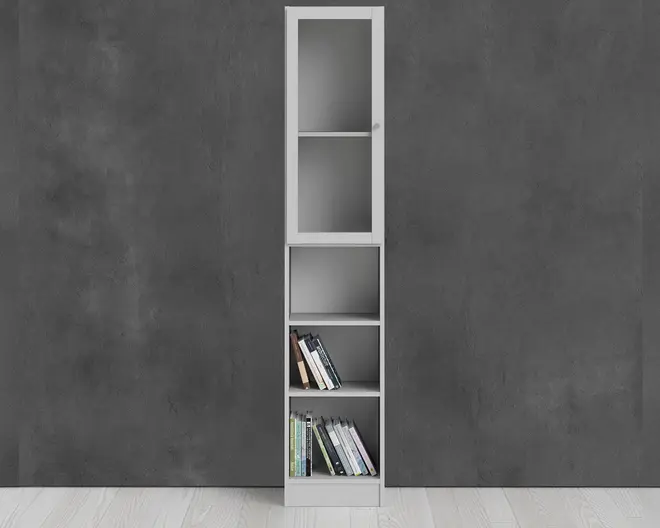 Høj, smal reolenhed med et moderne design og hvid ramme. Den øverste del har en glaslåge med to hylder indeni, velegnet til at udstille genstande eller beskytte dem mod støv. Under glaslågen er der tre åbne hylder, hvoraf to indeholder et lille udvalg af bøger, der står lodret og læner sig til den ene side. Enheden står på et lyst trægulv op ad en mørkegrå væg.