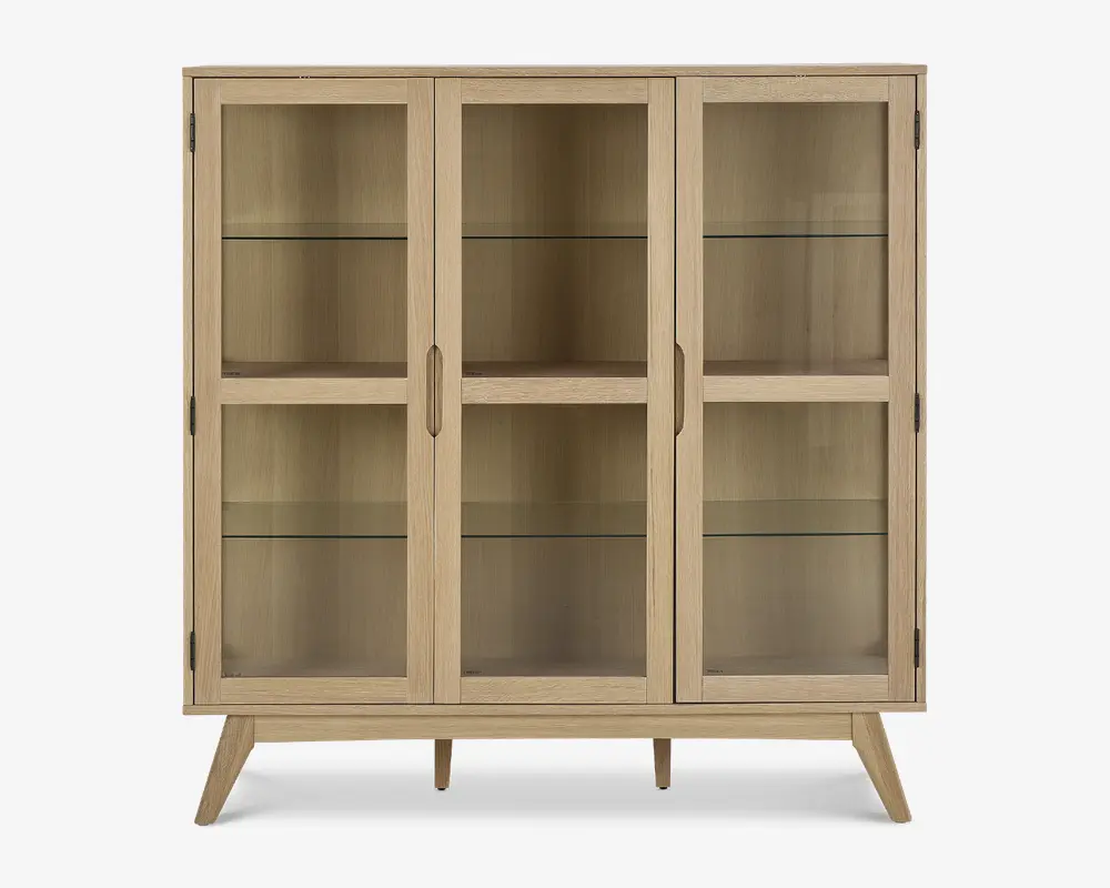 Rektangulært skab med tre glaslåger, lys træramme og skråtstillede ben. Indeholder to indvendige glashylder i hver sektion, hvilket giver god plads til udstilling. Håndtagene er integreret i træet for et stilrent og minimalistisk udtryk.
