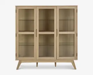 Rektangulært skab med tre glaslåger, lys træramme og skråtstillede ben. Indeholder to indvendige glashylder i hver sektion, hvilket giver god plads til udstilling. Håndtagene er integreret i træet for et stilrent og minimalistisk udtryk.